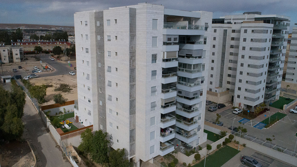 מבט צד לחזית בניין מגורים בן 11 קומות בדימונה
